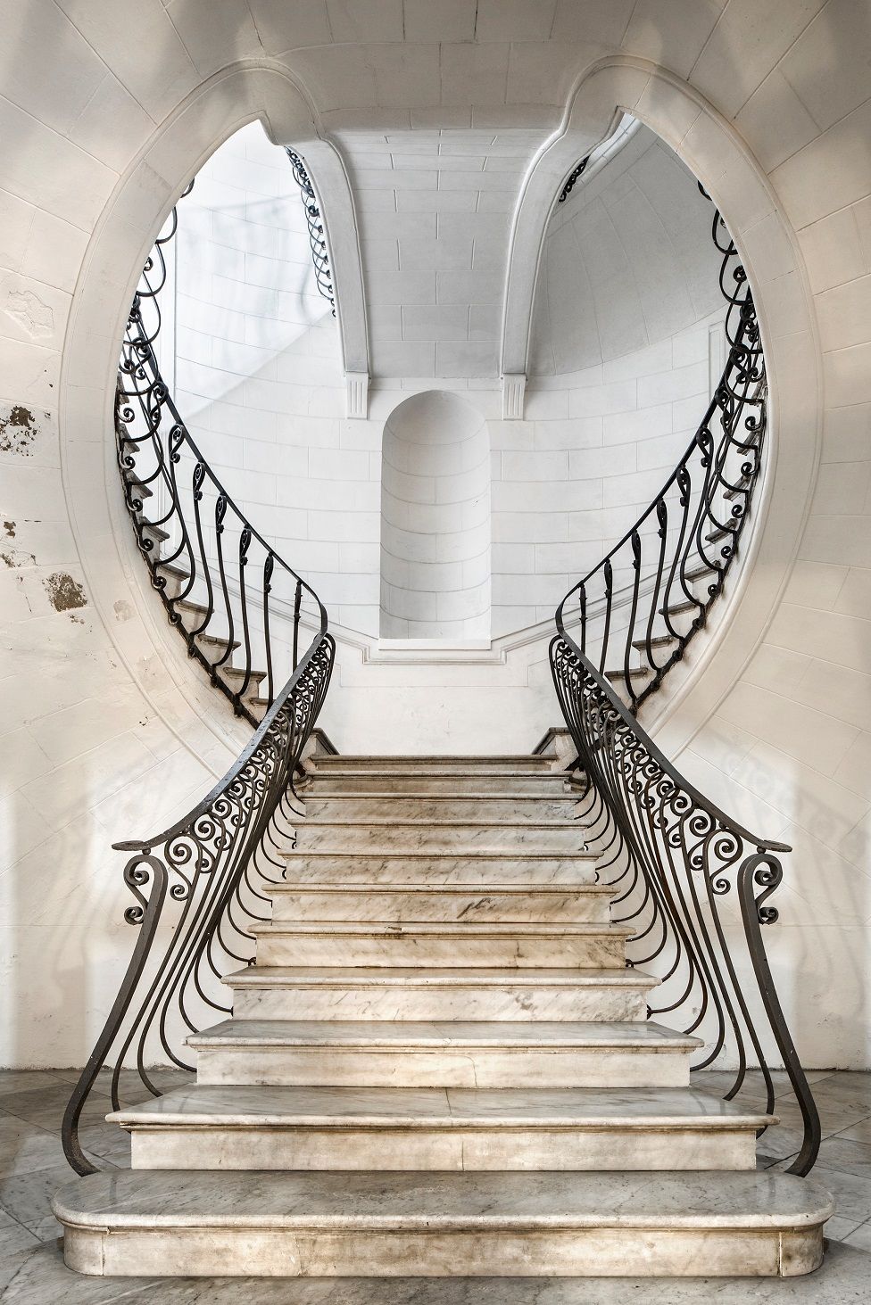 An ornate staircase of white stone and marble