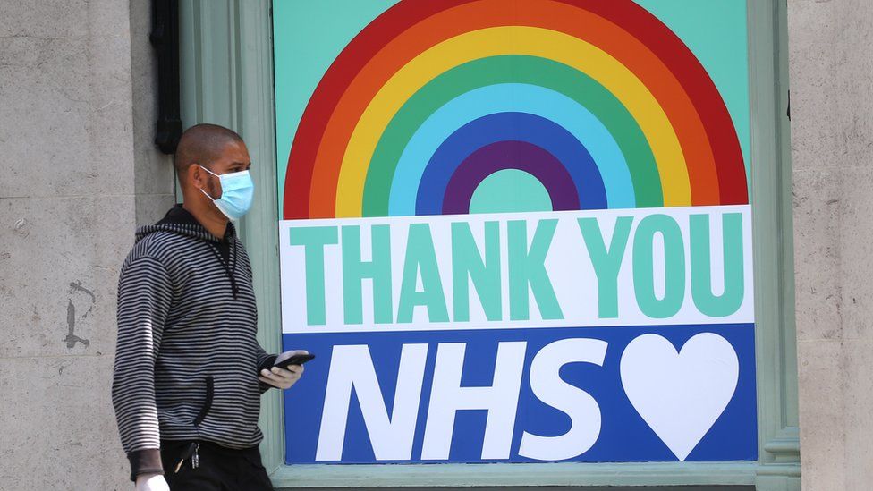 A man walks past a thank you message to the NHS in central London on April 16, 2020