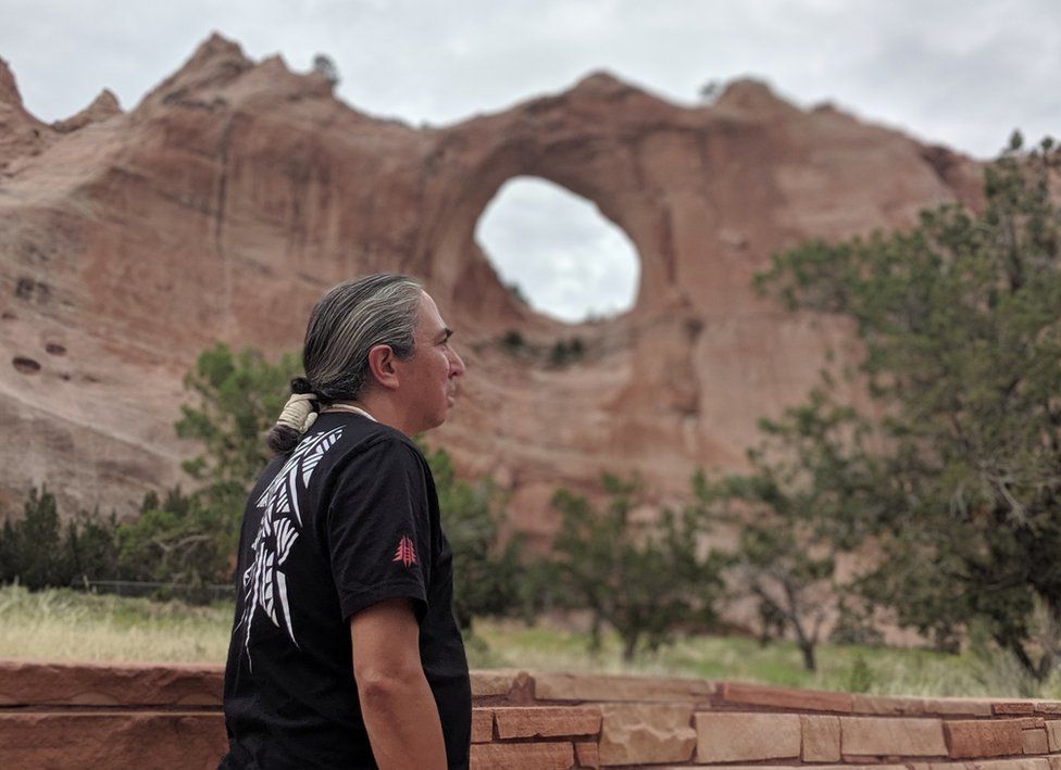 Mark Charles pictured with the landmark Window Rock in the background