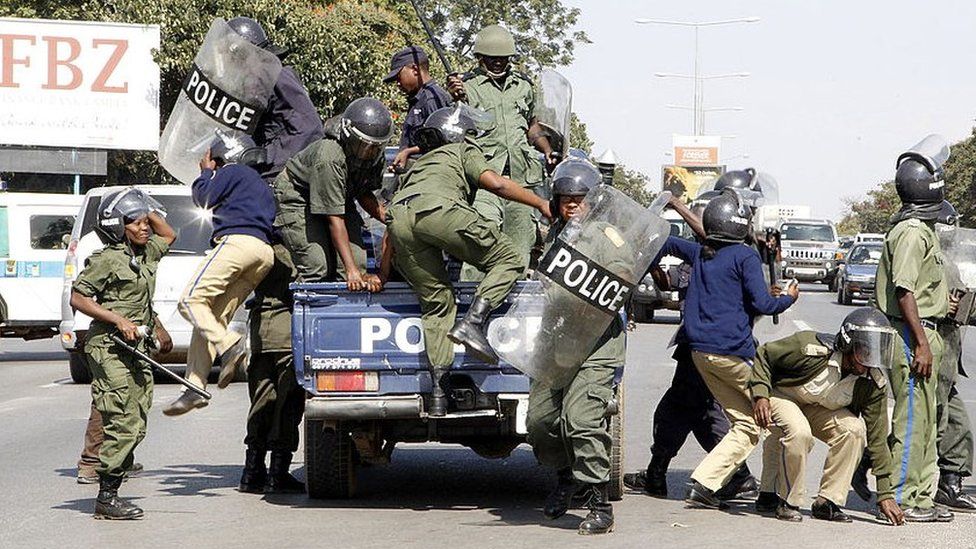 Zambian police officers arrive at the University of Zambia where students protest against the government’s removal of fuel and mealie meal subsidies on May 17, 2013 in Lusaka