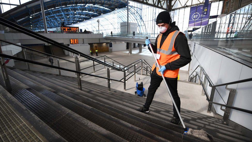 Railway station staff clean the steps at London's Waterloo station