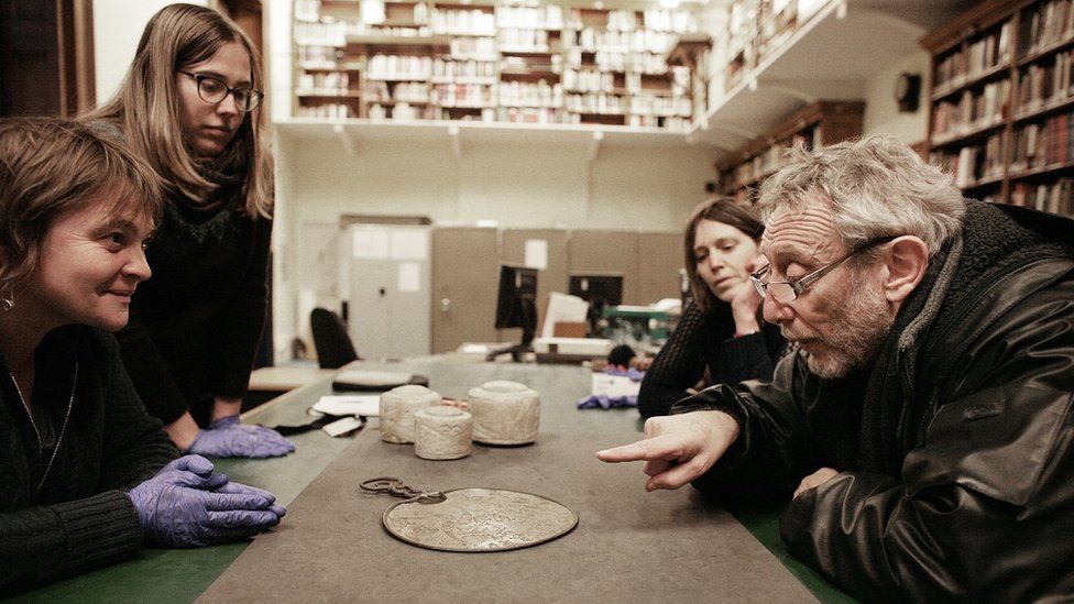 Michael Rosen and archaeologists looking at the Desborough mirror - similar to the Portesham mirror