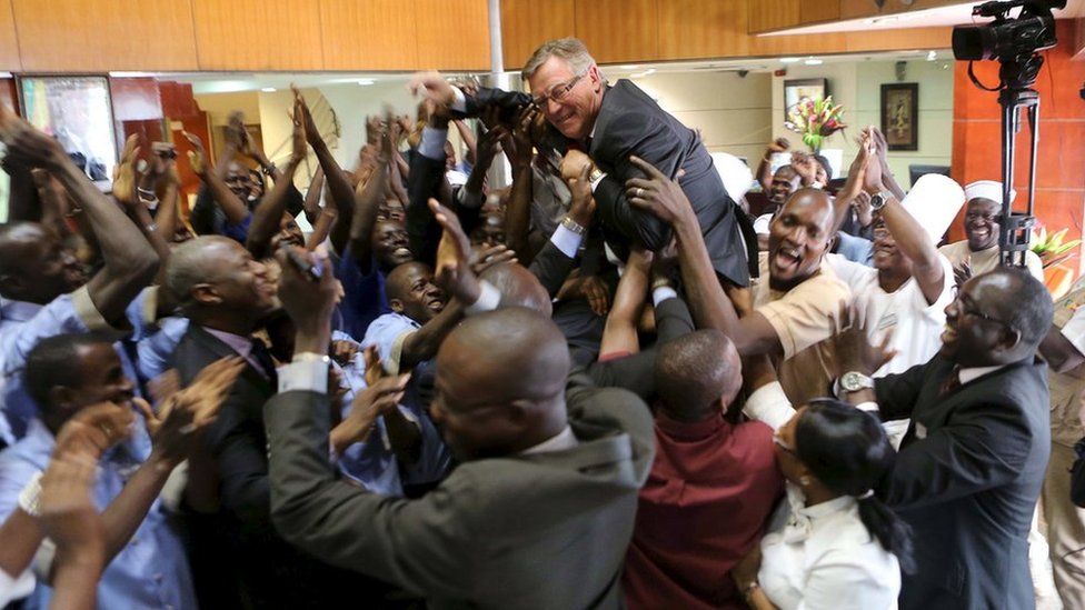 Workers celebrate with Radisson Blu hotel manager Gary Ellis after the hotel reopened in Bamako, Mali, 15 December