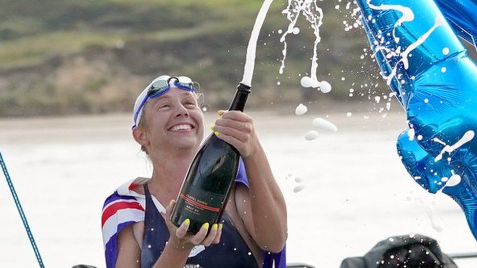 Chloe McCardel popping a champagne bottle