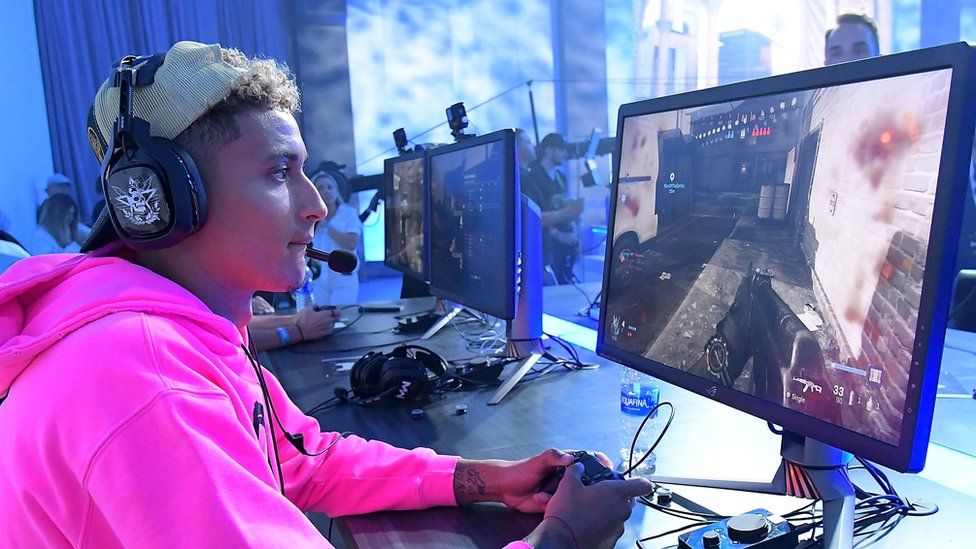 Man in pink jumper playing call of duty