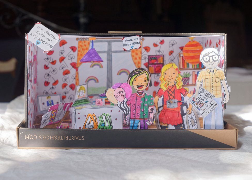 a family box created by a child showing a family made of cut out pieces of paper inside a shoebox