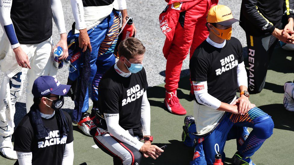 Sergio Perez (left), Romain Grosjean (centre) and and Lando Norris take a knee in support of the Black Lives Matter movement, before the Austrian Grand Prix