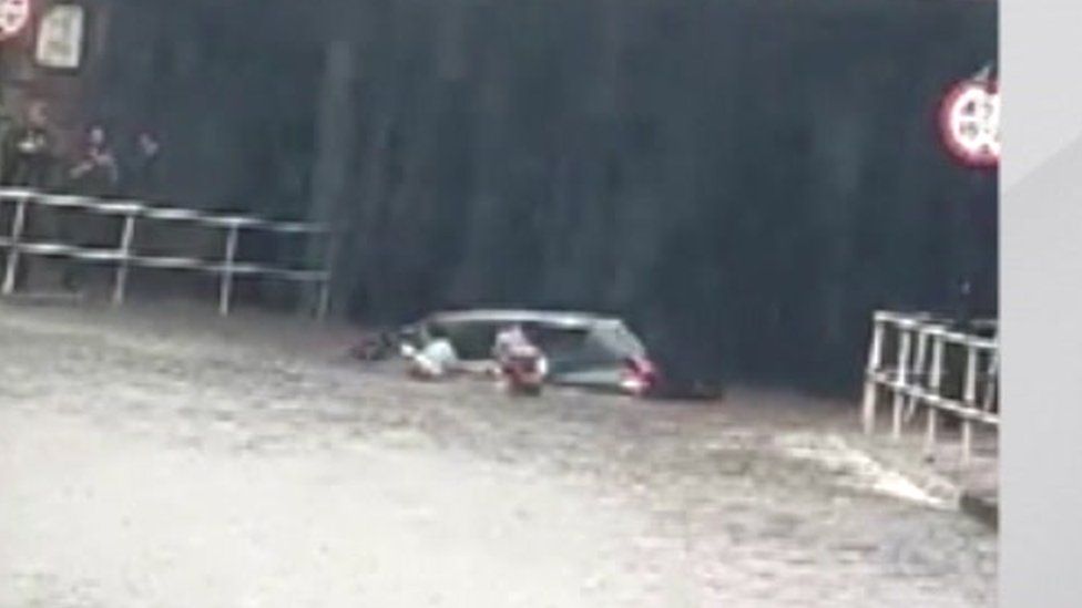 People emerge from a car stuck in floodwater in Sheffield on Sunday