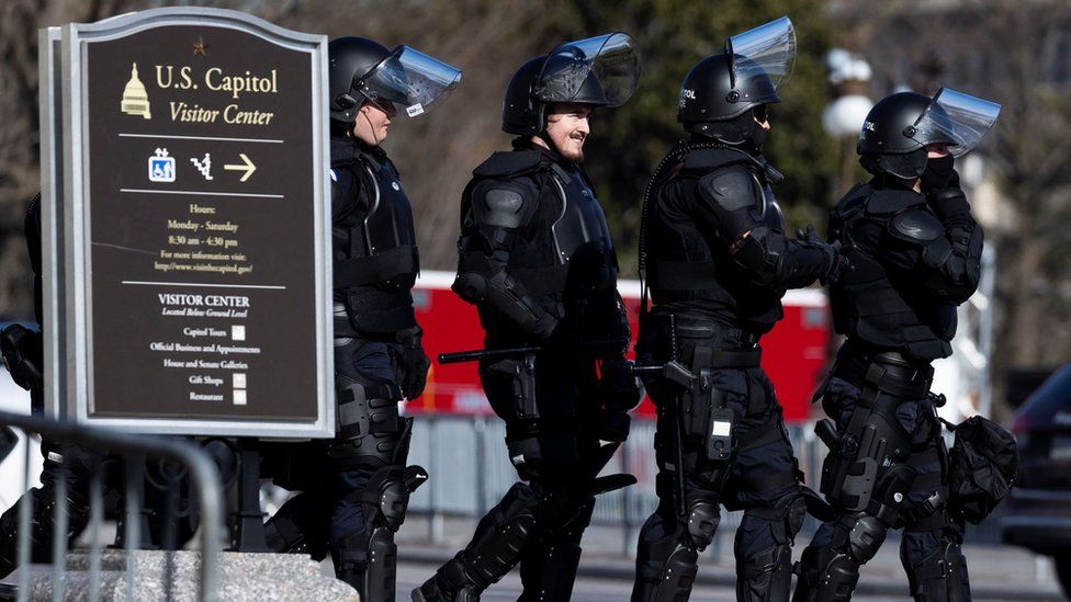 За день до инаугурации Капитолий США Офицеры полиции в спецодежде гуляют по территории вокруг Капитолия