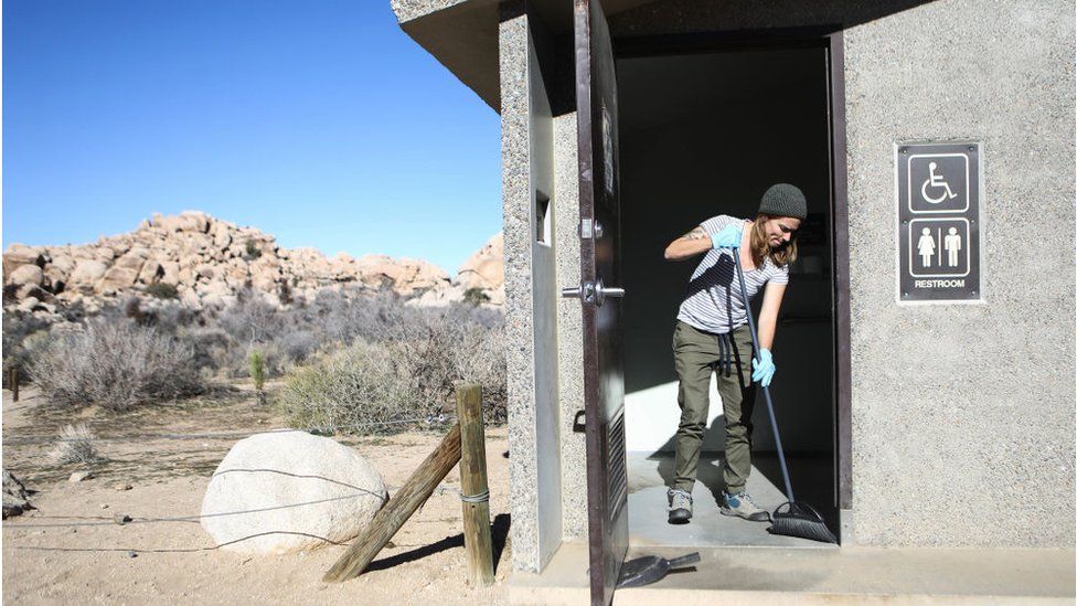 A volunteer cleans a restroom at Joshua Tree National Park