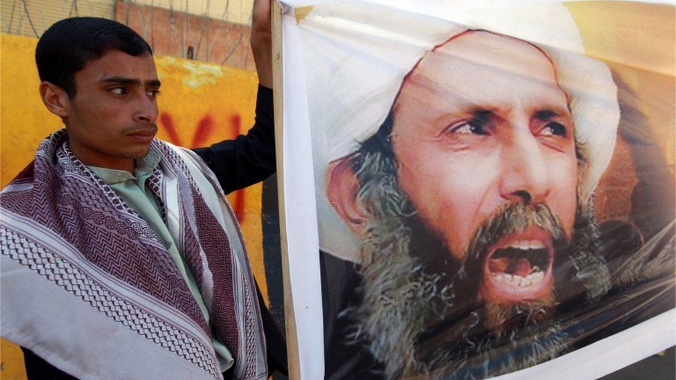 A file picture taken in the Yemeni capital Sanaa on October 18, 2014, shows a protester taking part in a demonstration outside the Saudi embassy against the death sentence on Saudi Shiite cleric and anti-government protest leader, Nimr al-Nimr (portrait), after he was convicted by Saudi authorities of sedition.