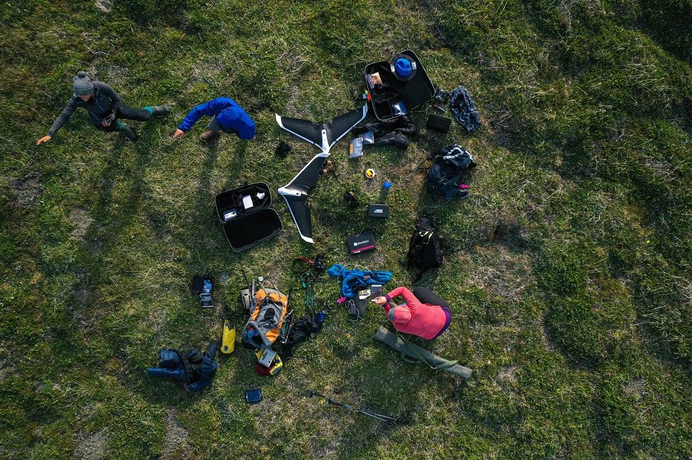 An aerial view of scientists working on a drone