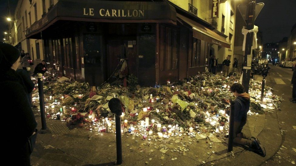 People pray outside Le Carillon restaurant, one of the attack sites in Paris, November 15, 2015.