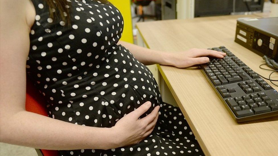 Pregnant woman at her desk