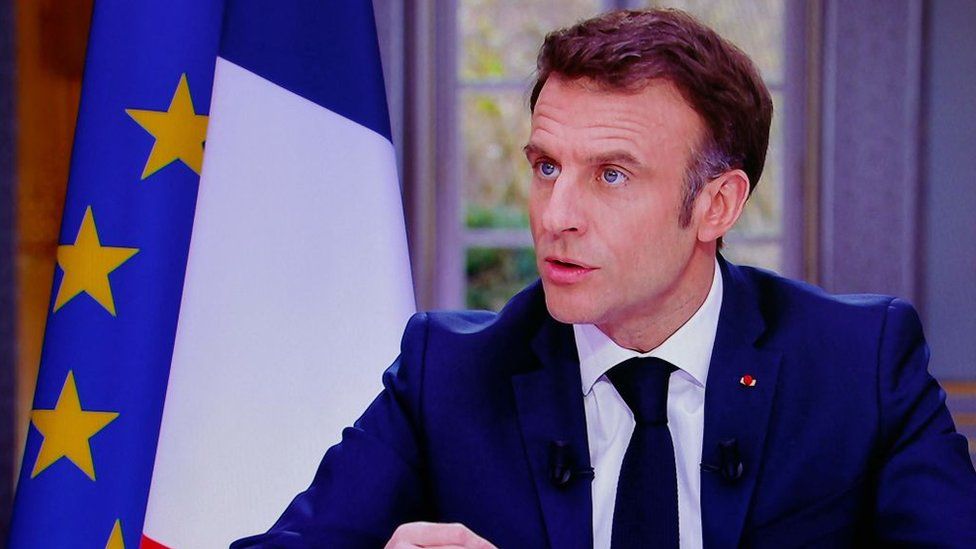 French President Emmanuel Macron is seen on screen as he speaks during a TV interview from the Elysee Palace, in Paris, on March 22, 2023