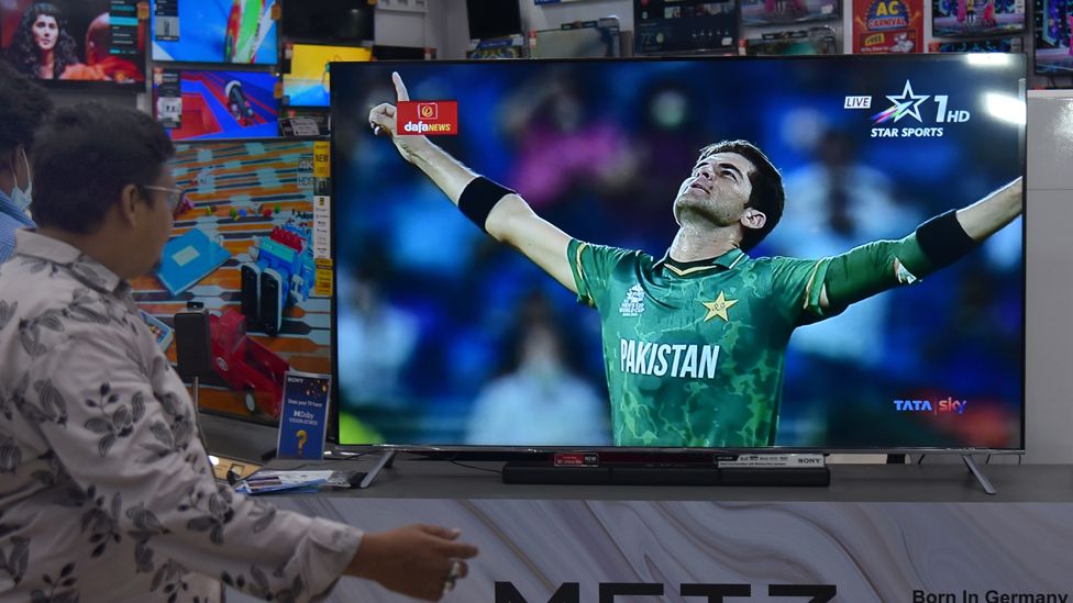 An Indian cricket fan watches the first match between India and Pakistan International Cricket T20 World Cup Super 12 stage in Dubai, live on a television screen at an electronic store, in Chennai, India, 24 October 2021.