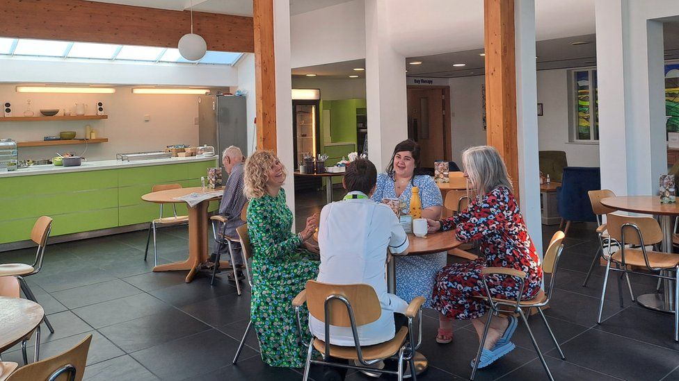 People sit around a table in a cafe