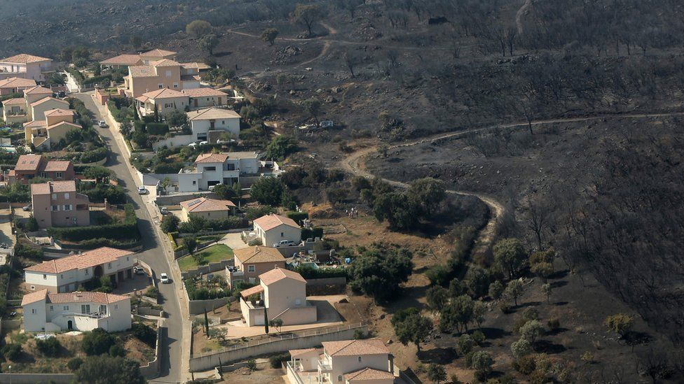 An aerial view taken on July 25, 2017 shows the fire devastated landscape in Biguglia, on the French Mediterranean island of Corsica.