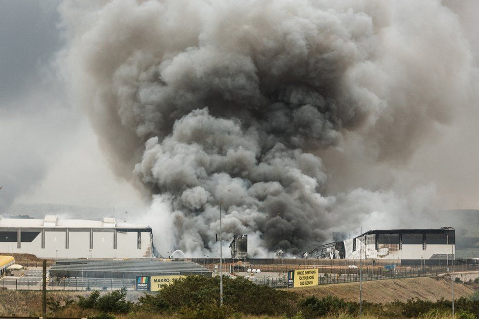 Smoke rises from a Makro building set on fire overnight in Umhlanga, north of Durban, on 13 July 2021