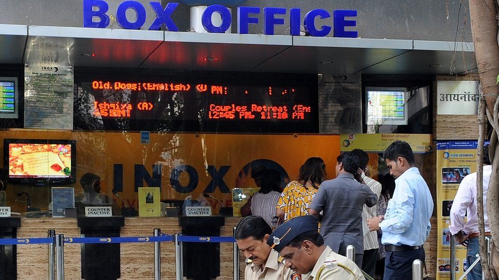 Policemen sitting outside a movie hall in India