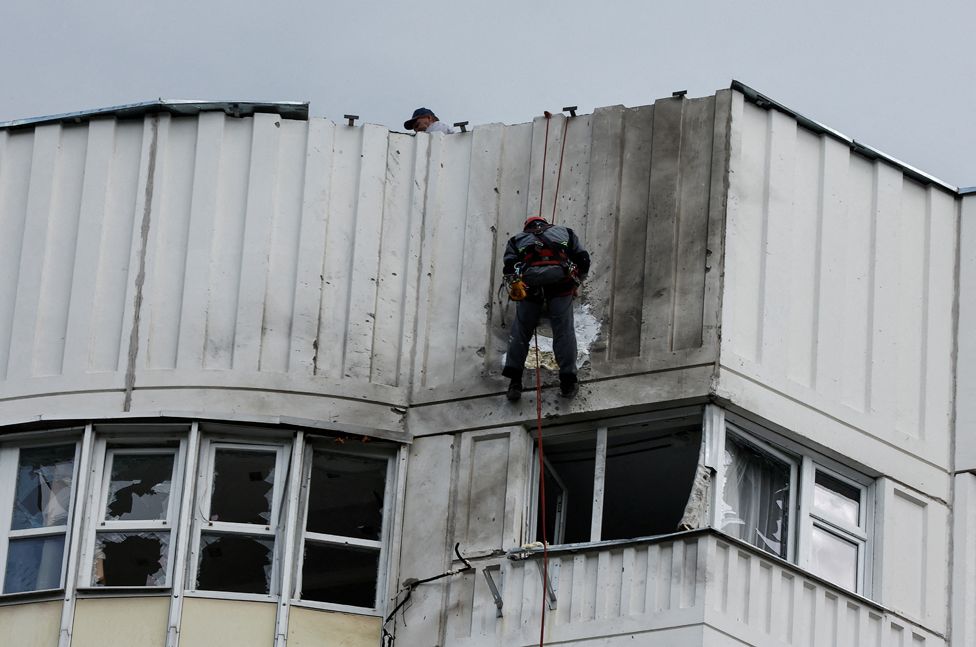 Workers repair damage on the roof of an apartment block, following a reported drone attack in Moscow, Russia, 30 May 2023.