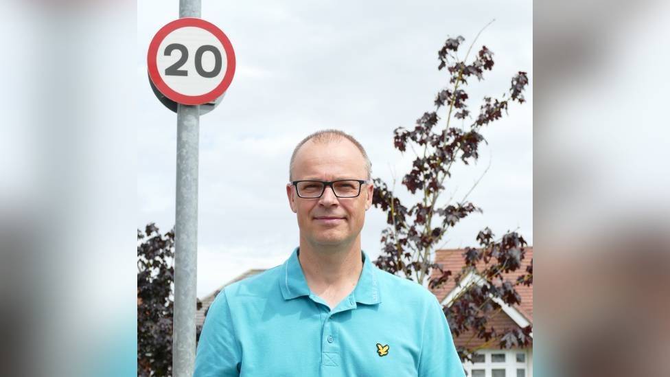 Martin Bailey standing in front of a 20mph sign