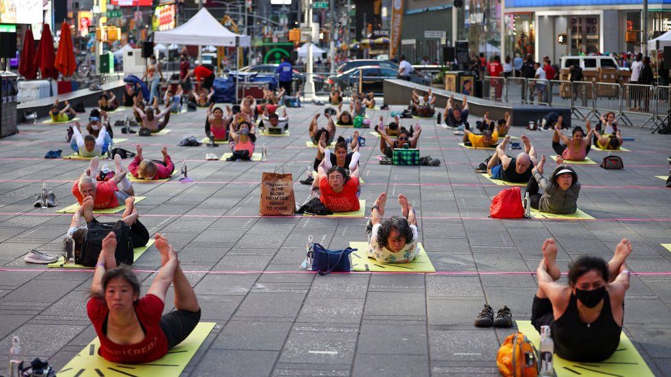 Люди занимаются йогой на Таймс-сквер в рамках мероприятия «Международный день йоги» в день летнего солнцестояния в Нью-Йорке, США, 20 июня 2021 года.