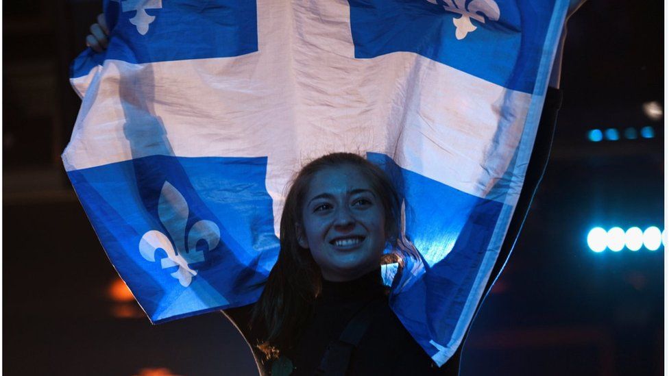 A supporter of the Bloc Quebecois waves a flag