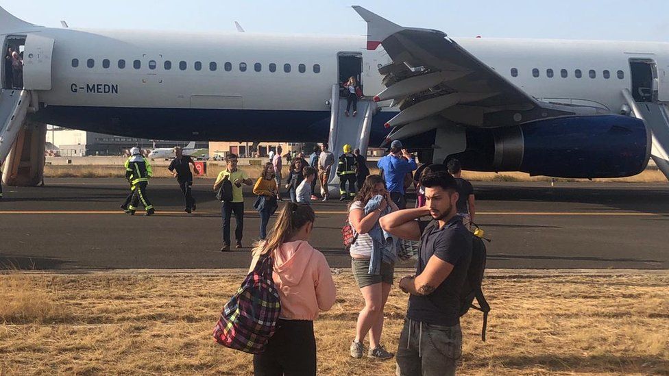 Passengers disembarking via emergency chute from the flight in Valencia