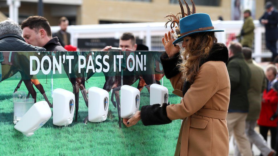 Race goers use hand sanitiser installed at Cheltenham Racecourse to help curb the spread of the Corona Virus at Cheltenham Racecourse on March 10, 2020 in Cheltenham, England.