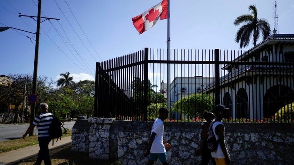 People walking past the Canadian embassy in Havana