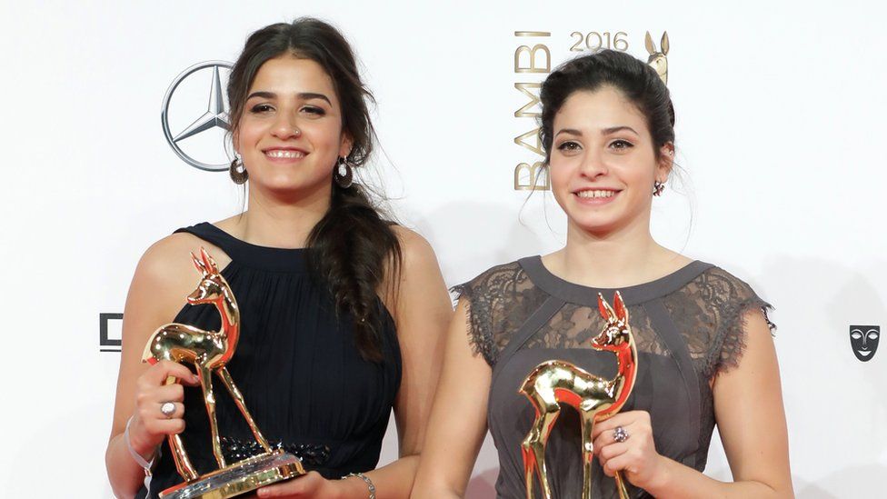 Yusra Mardini and her human rights worker sister Sarah Mardini pose with their Unsung Heroes awards