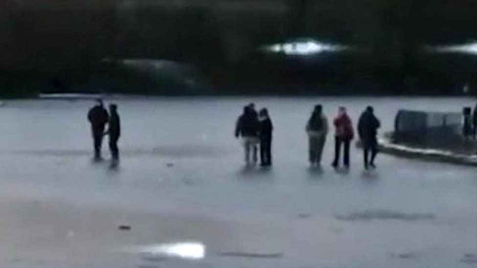 People skating on icy pond