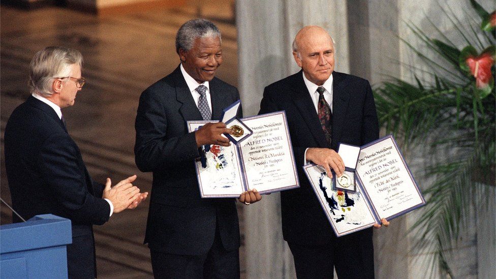 Nelson Mandela, President of South African African National Congress (C) and South African President Frederik de Klerk (R) display 09 December 1993 in Oslo their Nobel Prizes after being awarded jointly for their work to end apartheid peacefully.