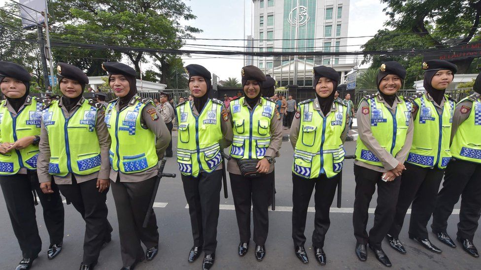 Indonesian policewomen stand guard as Muslims march towards the presidential palace during a protest against Jakarta governor Basuki Tjahaja Purnama also known as Ahok over an alleged blasphemy in Jakarta on November 4, 2016