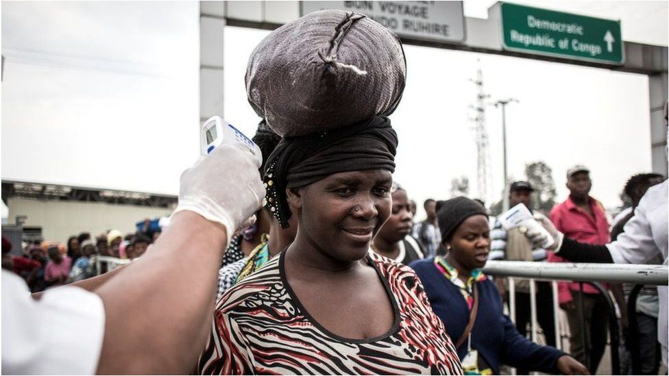 A woman gets her temperature measured at an Ebola screening station as she enters Rwanda from the Democratic Republic of the Congo