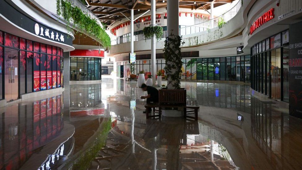 A man sits in the hallway in front of empty Forest City Outlet Mall, a development project launched under China's Belt and Road Initiative in Gelang Patah in Malaysia's Johor state on September 1, 2023
