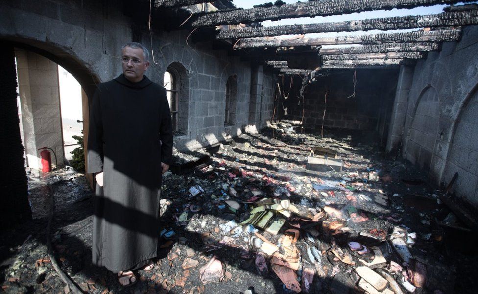 Priest inspects the damage at a room located on the complex of the Church of the Multiplication at Tabgha, on the shores on the Sea of Galilee in northern Israel, on June 18, 2015,