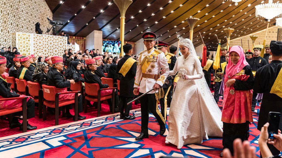 Prince Abdul Mateen and Yang Mulia Anisha Rosnah walk down the aisle during their wedding reception at Istana Nurul Iman in Brunei's capital Bandar Seri Begawan on January 14, 2024.