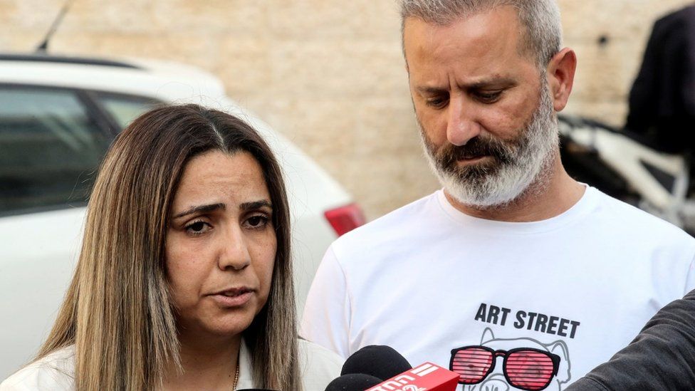 Natali Oknin (L) speaks to reporters after flying home to Israel with her husband Mordi (R) (18 November 2021)