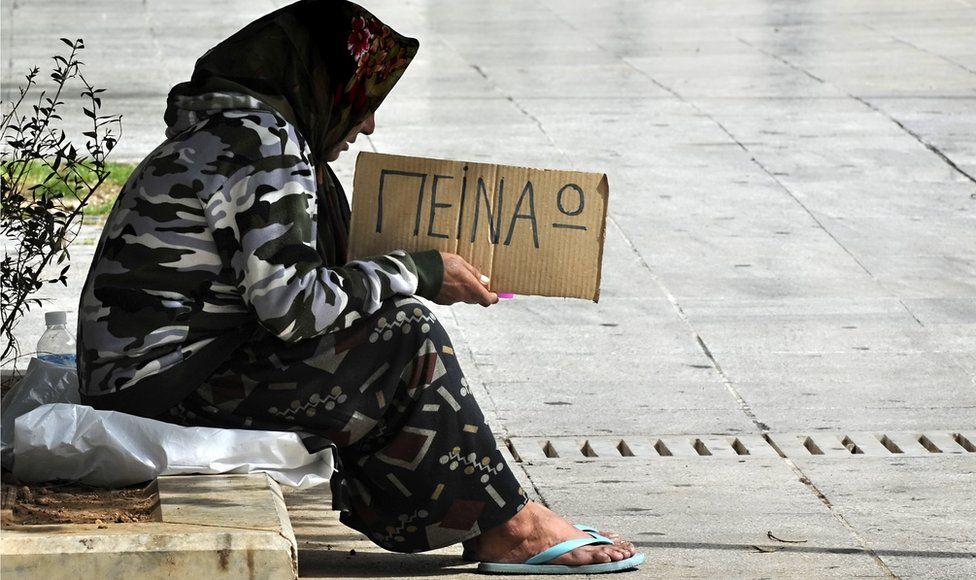 A woman holds a cardboard reading in Greek "I" m hungry" on 17 March 2011 in central Athens