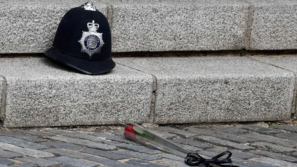 A single red rose placed in front of PC Palmer's helmet in Westminster ahead of his funeral