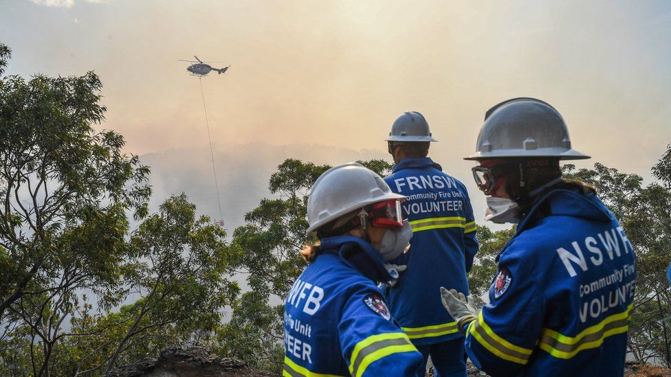 Firefighters use helicopters to dump water on the blaze