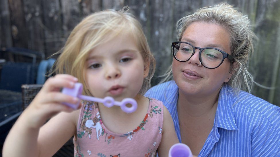Natalie Brewell and Luna blowing bubbles in a garden