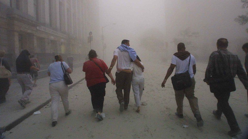 Civilians flee as a tower of the World Trade Center collapses September 11, 2001