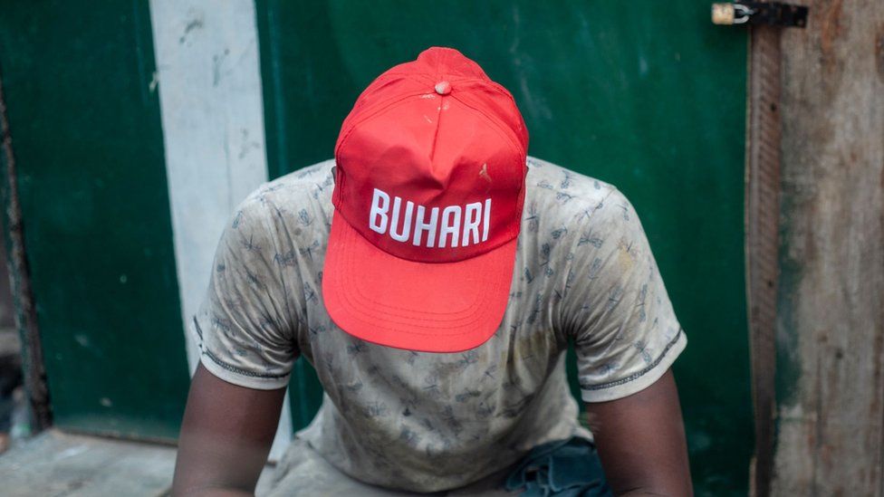 A young man wearing a cap bearing the name of Muhammadu Buhari
