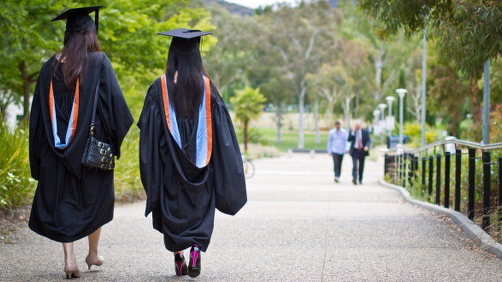 Two Chinese students walk after receiving their graduation diplomas from the Australian National University in Canberra