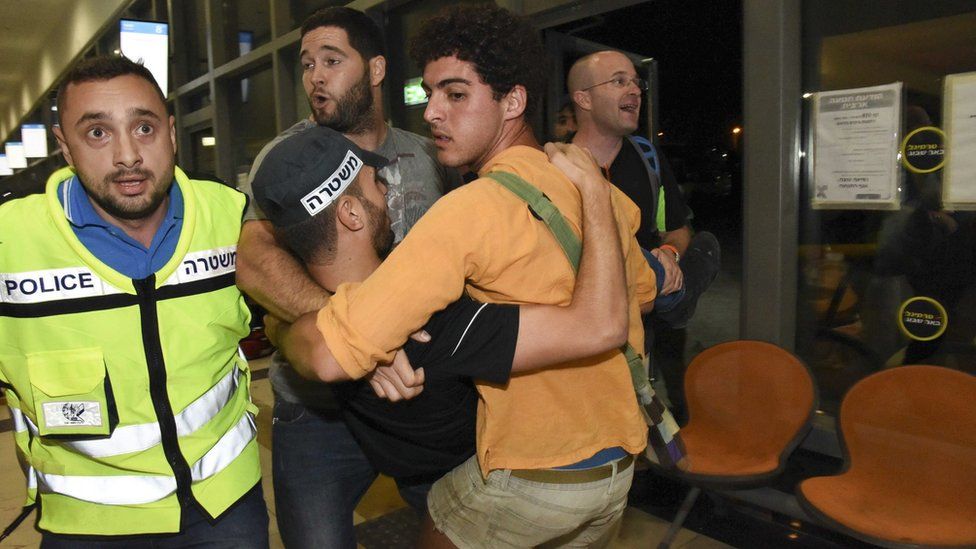 A wounded Israeli policemen is carried after a knife and gun attack in Beersheba, Israel (18 October 2015)