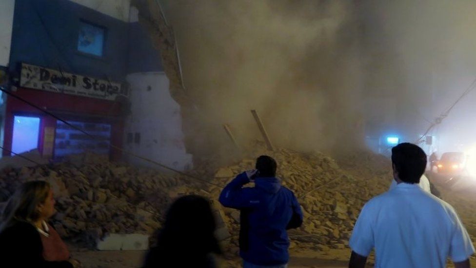 Passers-by stare at the rubble minutes after the collapse of the old Parravicini movie theatre building, in Tucuman, Argentina on May 23, 2018.