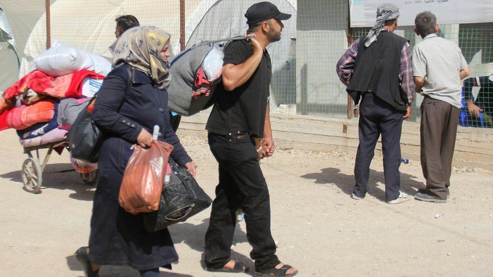 Syrians carry their belongings at a camp in rebel-held Idlib province after being evacuated from the Damascus district of Qaboun (15 May 2017)